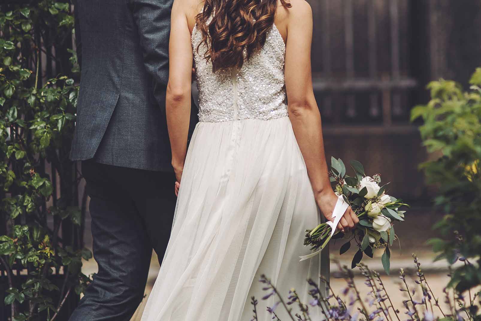 newly wed couple walking through a healthy garden